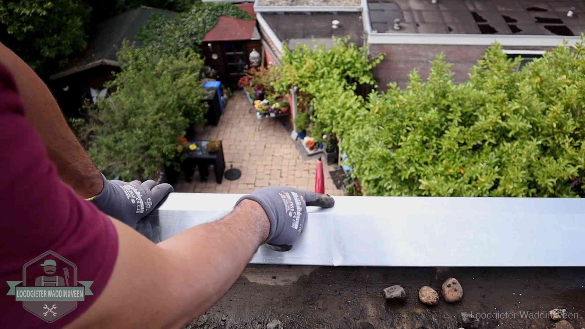 Daklekkage geregeld in Waddinxveen Vakman plaatst een daktrim op de dakrand van een woning in Waddinxveen