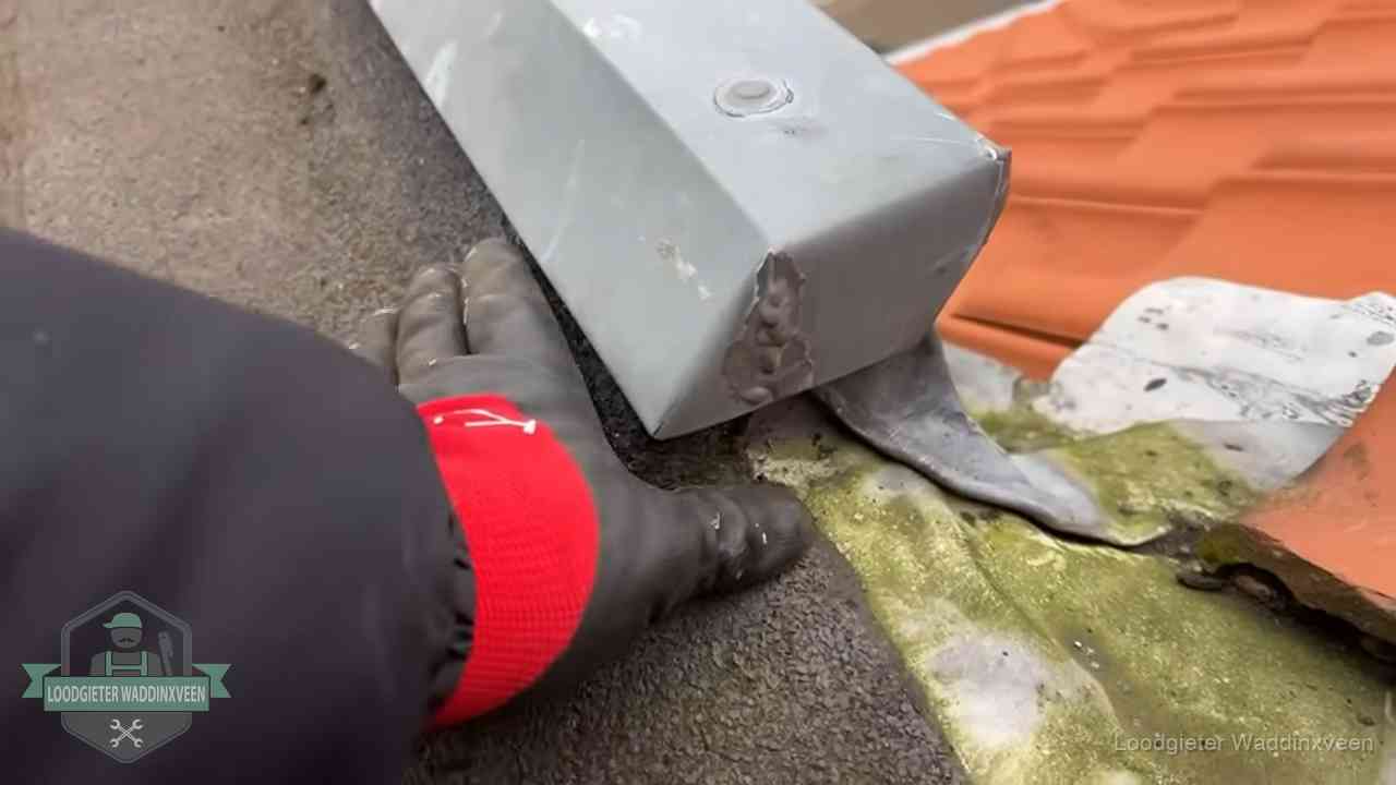 Hemelwaterafvoer en dakgoot controleren in Waddinxveen Controle van een zinken hemelwaterafvoer met loodslab bij dakpannen in Waddinxveen