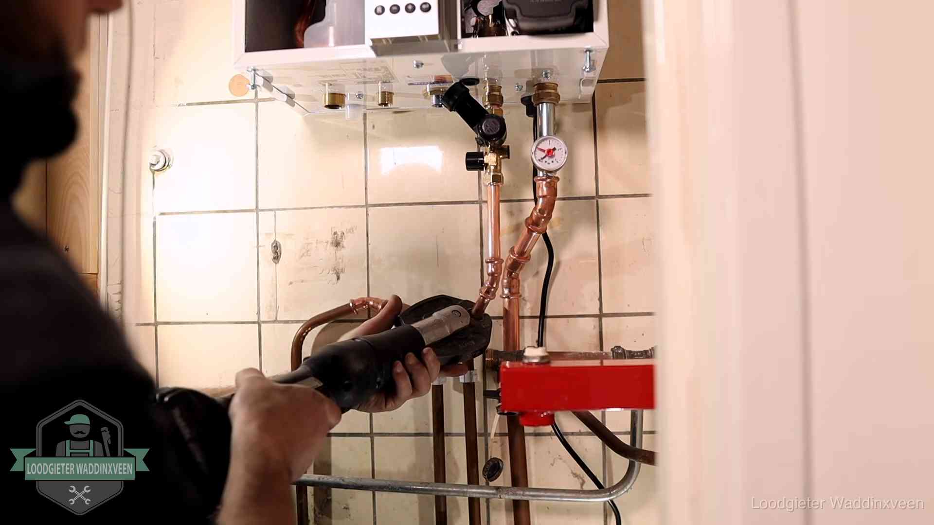 Cv-ketel onderhoud in Waddinxveen Monteur werkt aan de leidingen onder een cv-ketel in Waddinxveen