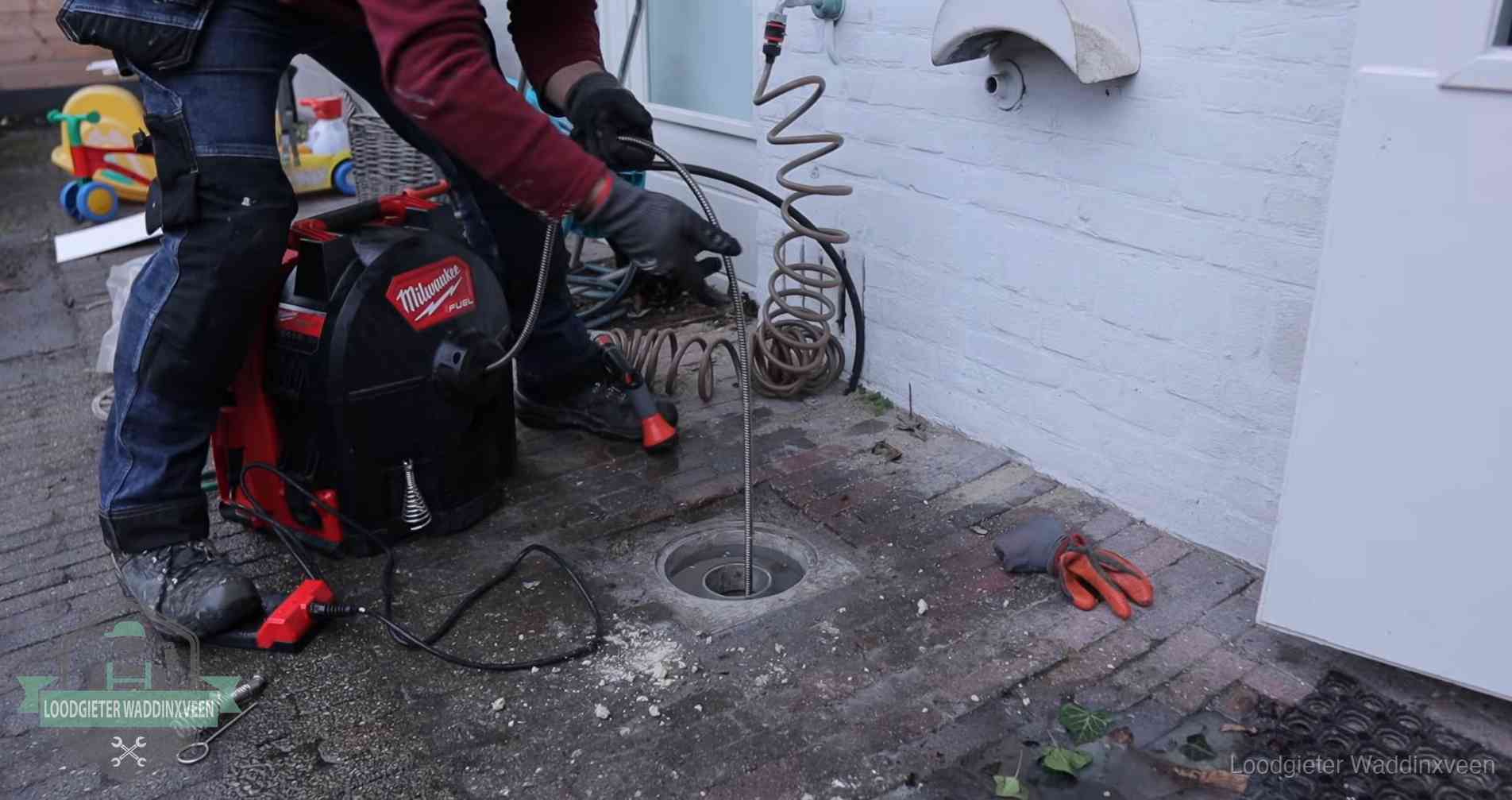 Erfgrens en gemeenteriool in Waddinxveen Ontstoppingsputje in de bestrating naast de gevel van een woning in Waddinxveen