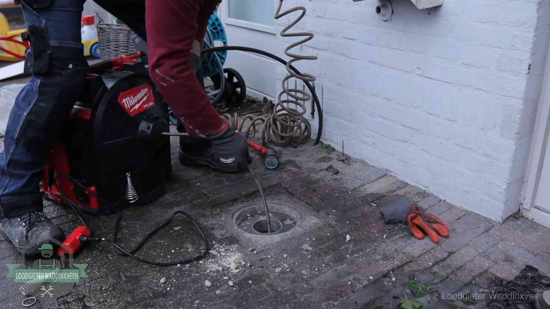 Prijs van een rioolontstopping in Waddinxveen Spiraalmachine bij een ontstoppingsputje in de bestrating in Waddinxveen