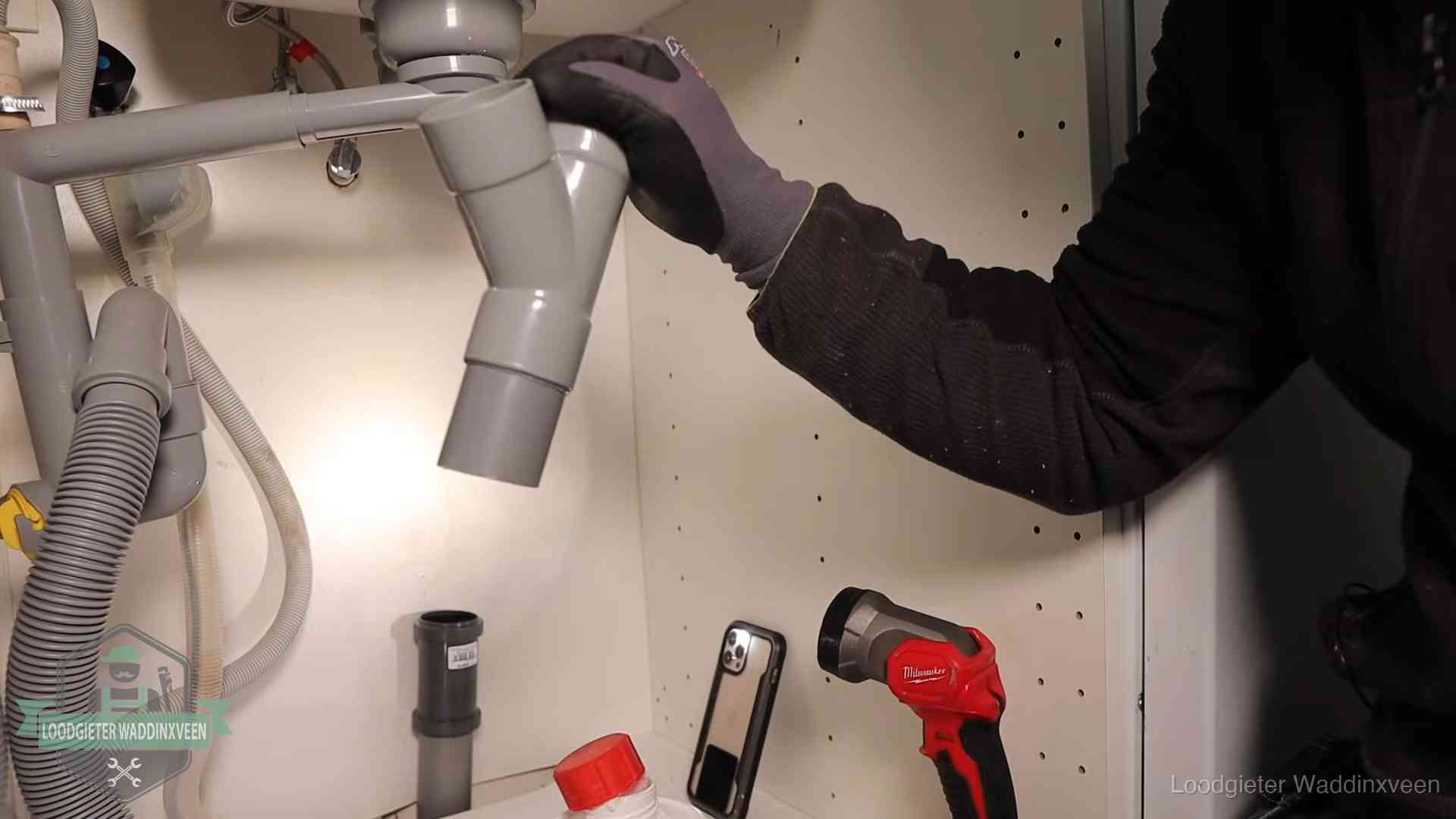 Rioollucht in huis verhelpen in Waddinxveen Loodgieter demonteert het sifon- en afvoerwerk onder een gootsteen in Waddinxveen bij stankklachten