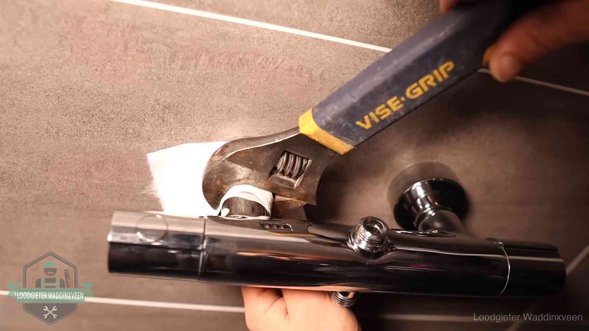 Loodgieter draait met beschermd gereedschap een kraan vast bij een spoedklus in Waddinxveen