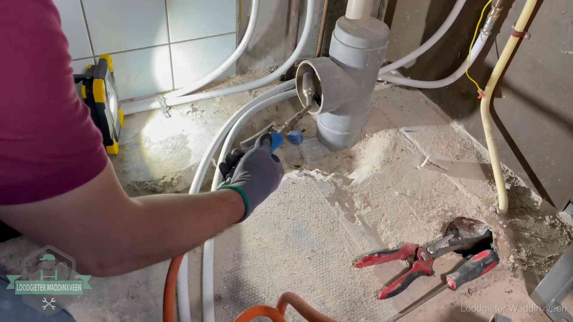 Loodgieter werkt aan leidingen bij een pvc-standleiding in een appartement in Waddinxveen