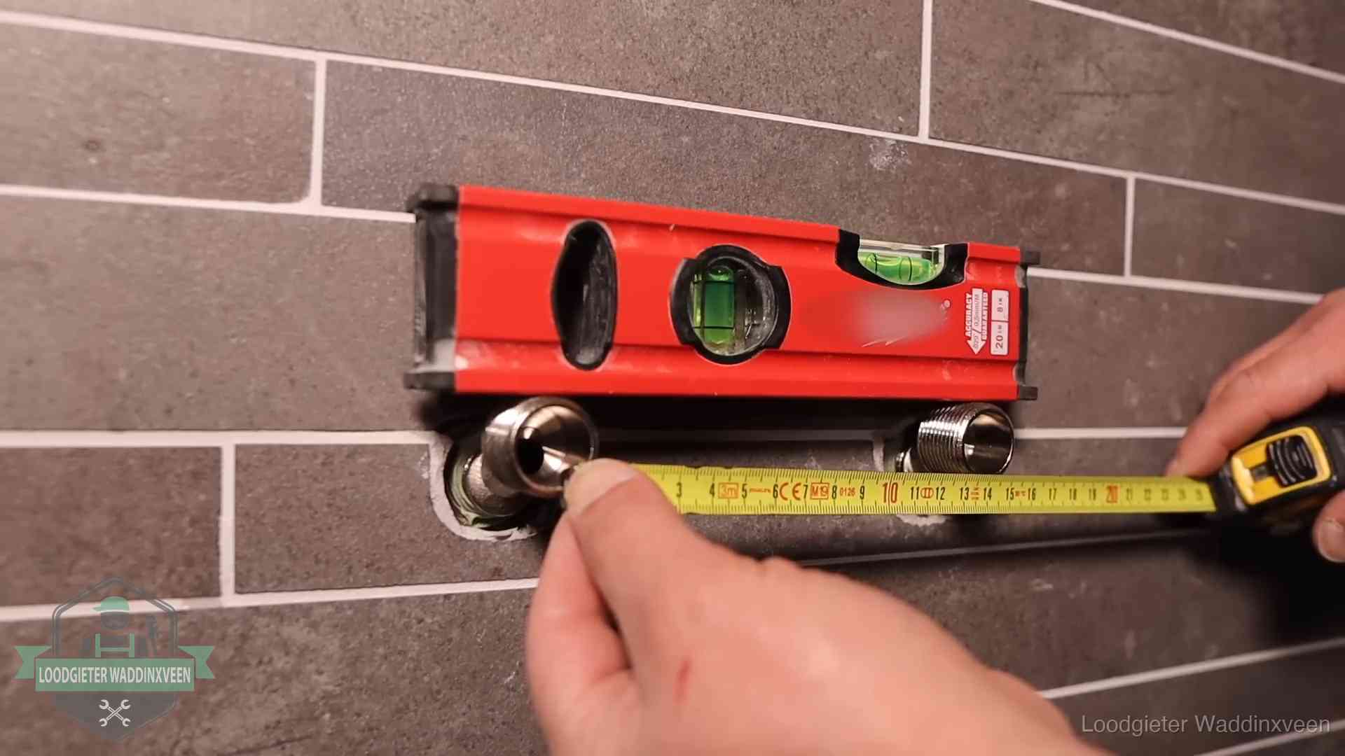 Waterpas en duimstok bij kraan-aansluitpunten in een badkamer in Waddinxveen