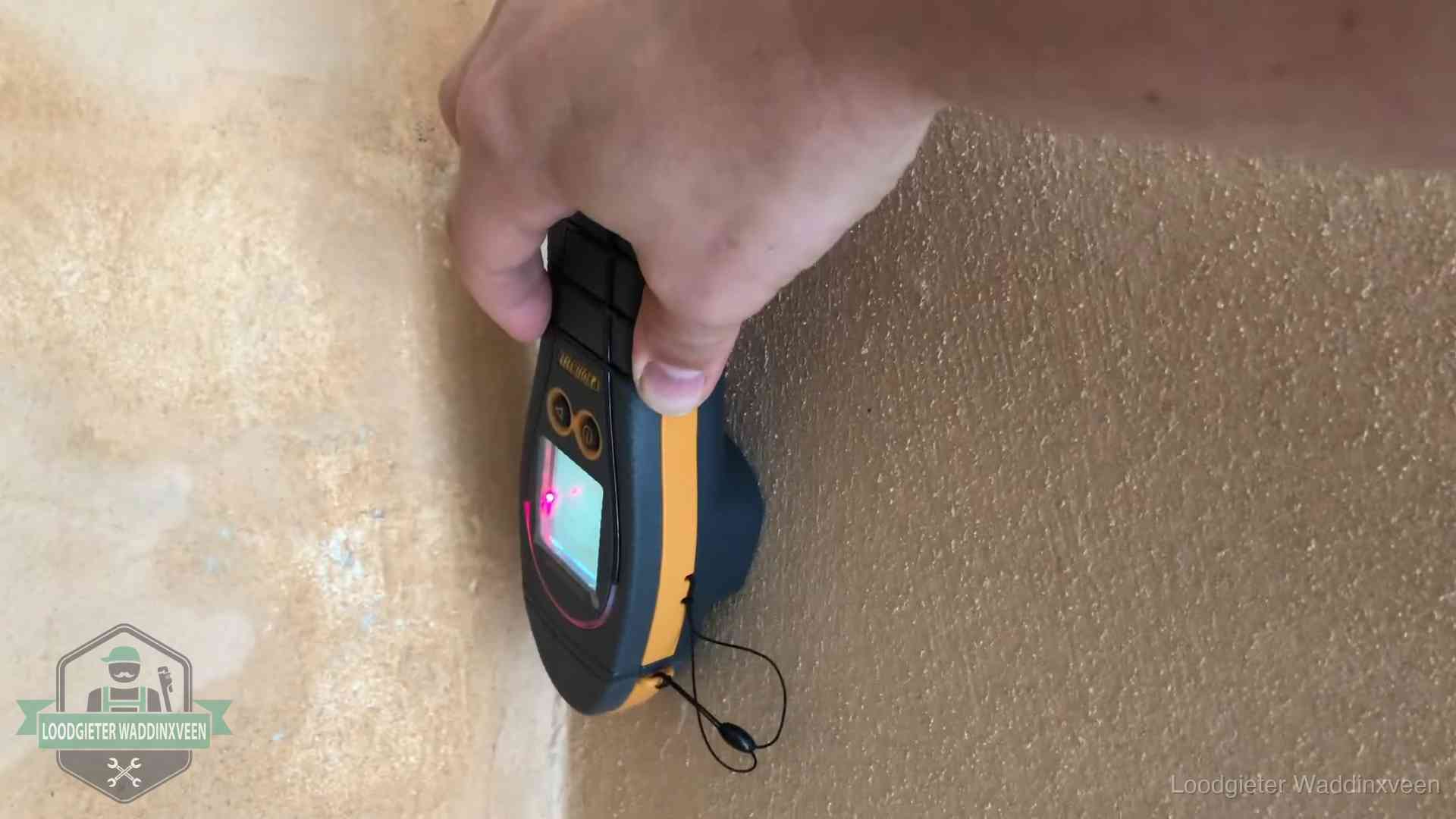 Daklekkage opsporen zonder hakwerk in Waddinxveen Vochtmeter tegen een muur met vochtplekken tijdens het opsporen van een daklekkage in Waddinxveen