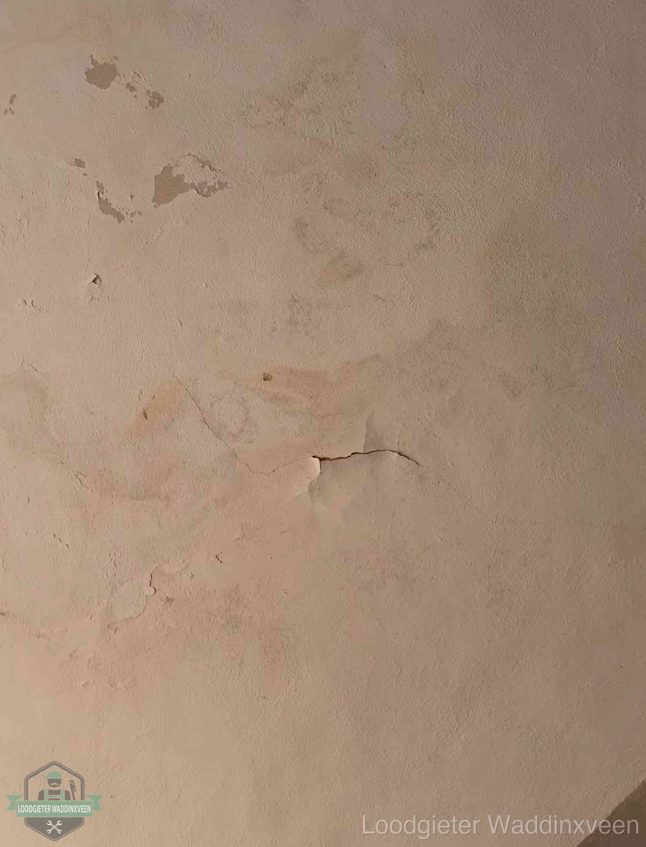Vochtkringen en afbladderende verf op een plafond in Waddinxveen, schade voor het meetrapport en de verzekering