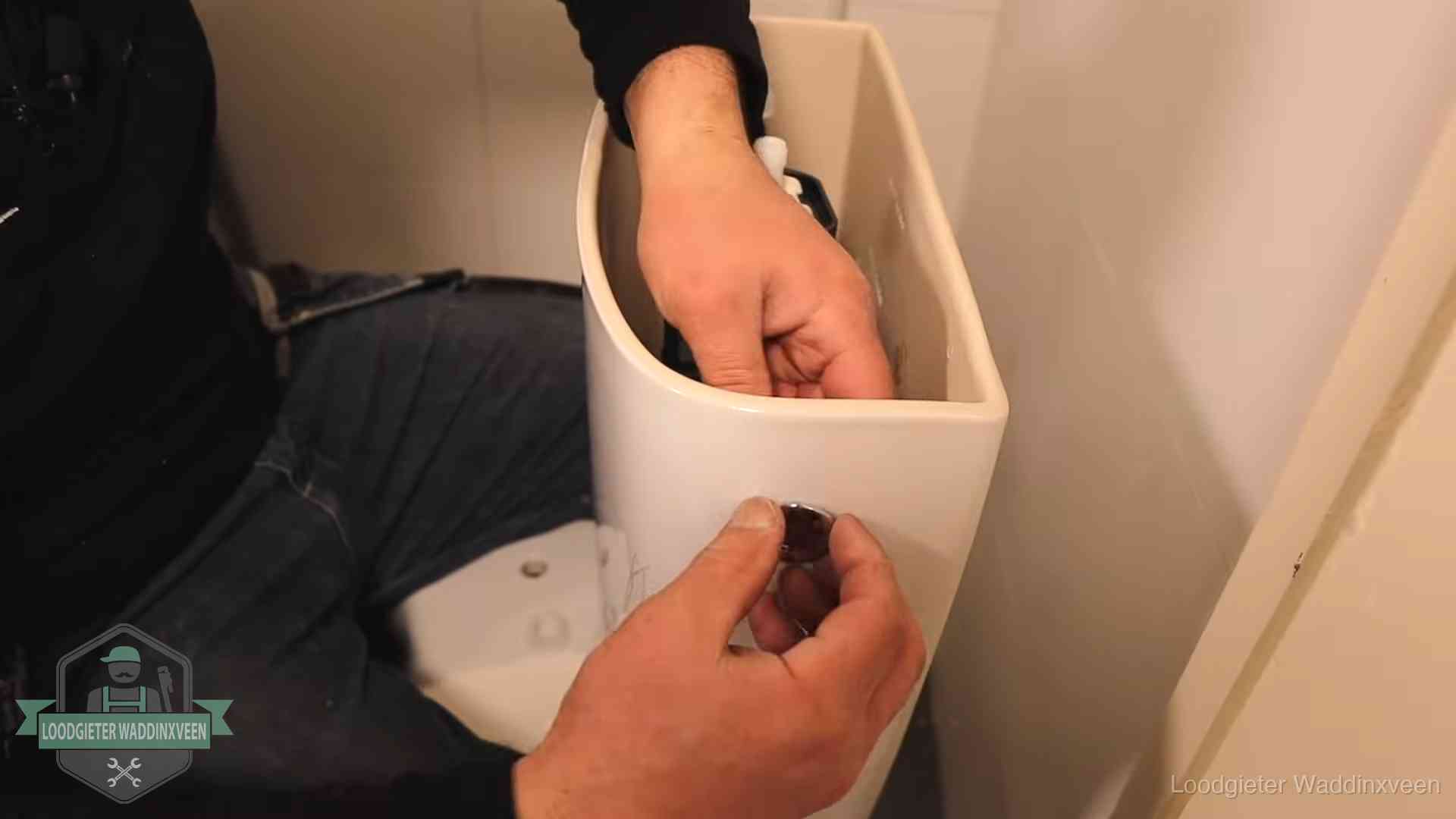 Je wc verstoppingsvrij houden in Waddinxveen Drukknop van een duoblok-stortbak wordt gemonteerd bij een toilet in Waddinxveen