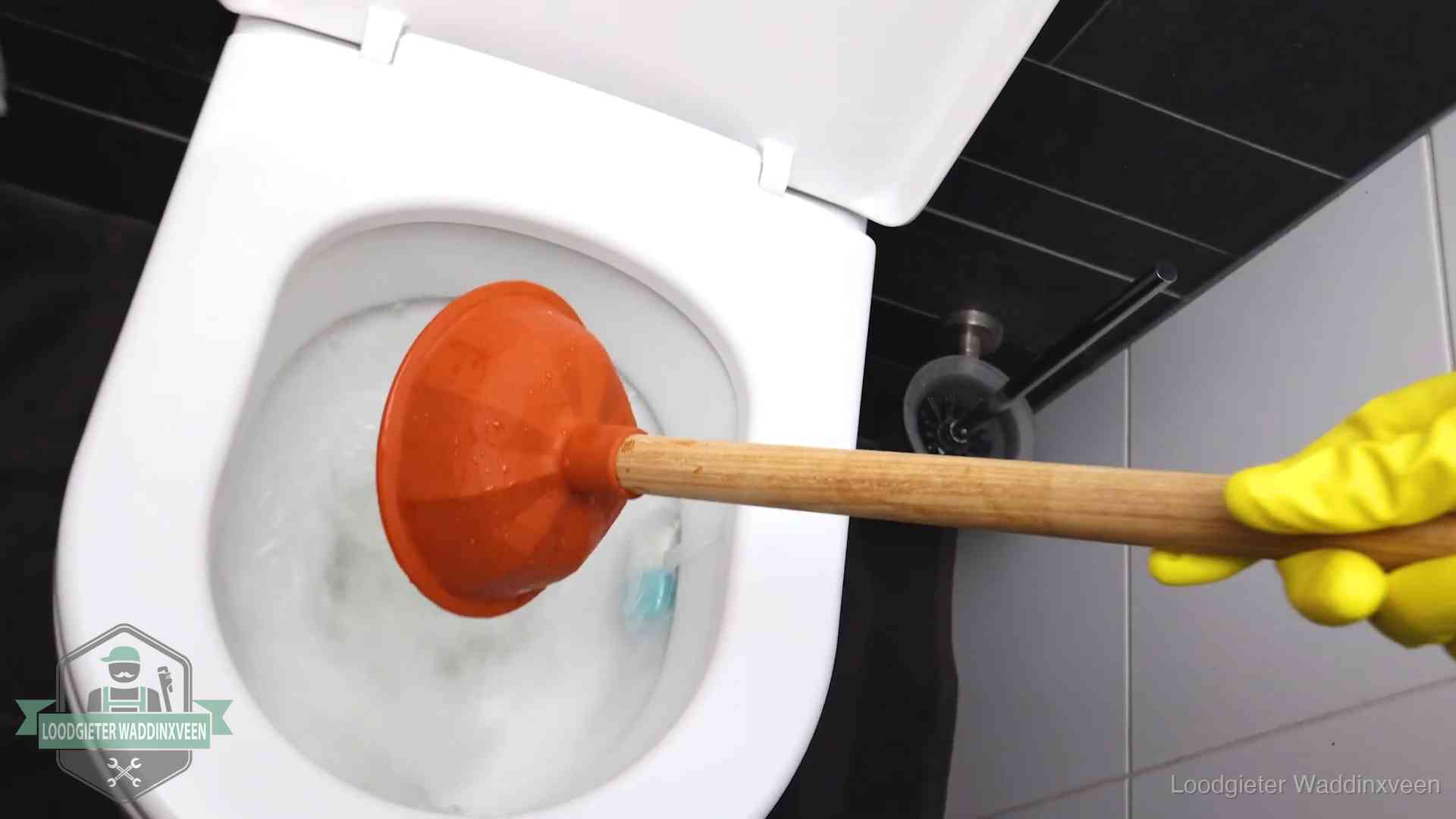 Wc ontstoppen met de plopper in Waddinxveen Plopper wordt in de wc-pot gedrukt bij het ontstoppen van een toilet in Waddinxveen