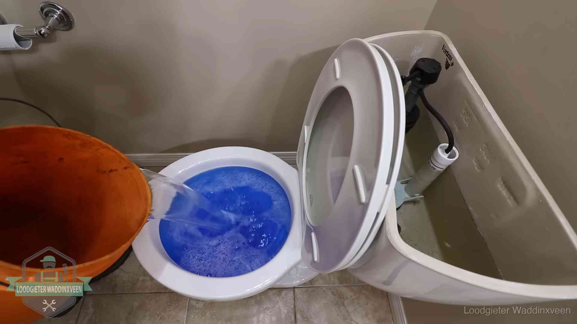 Water komt omhoog in de wc in Waddinxveen Water bij de wc-pot wordt met een emmer weggewerkt om schade te beperken in Waddinxveen